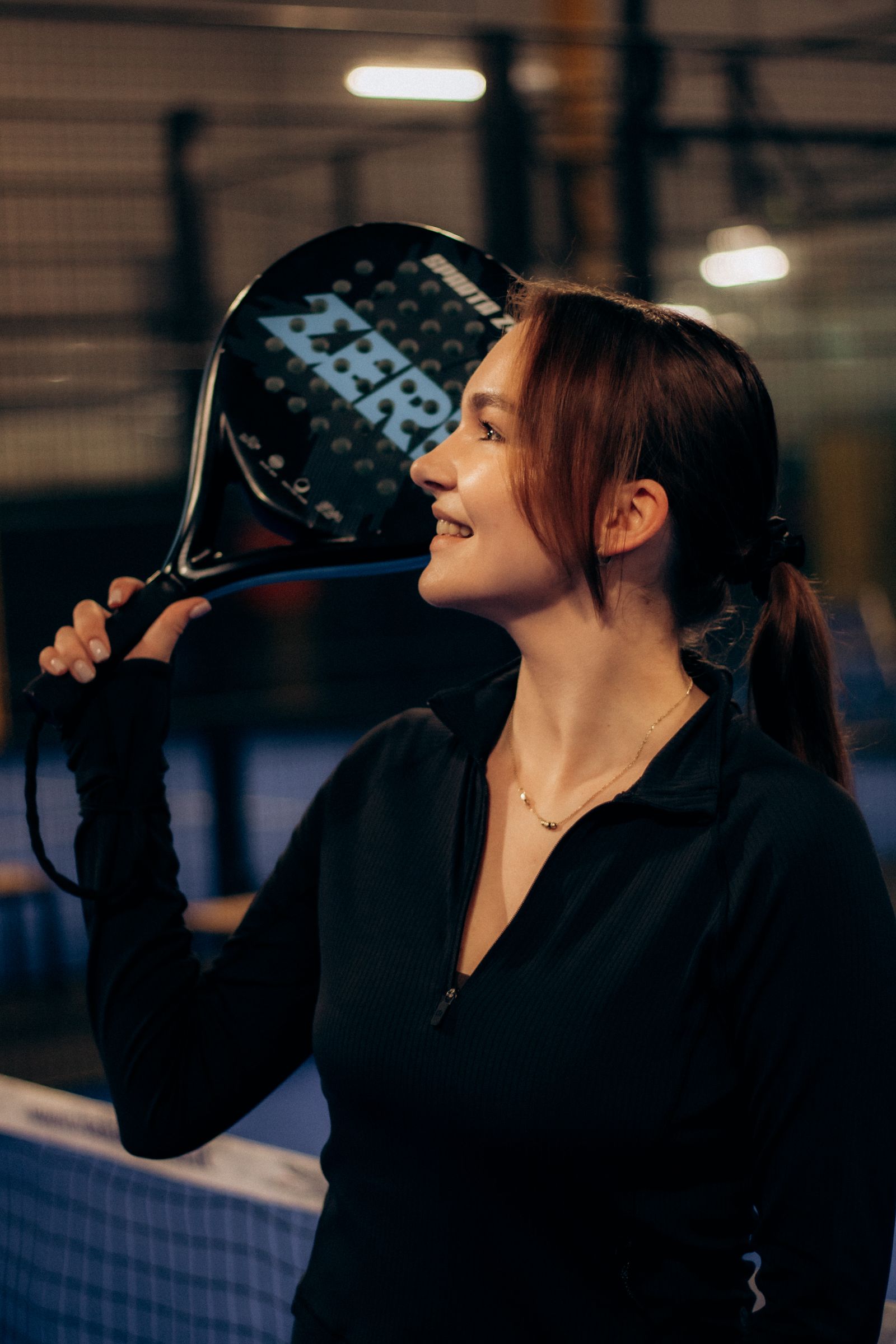 Padel-Spielerin mit Schläger auf dem Indoor-Court