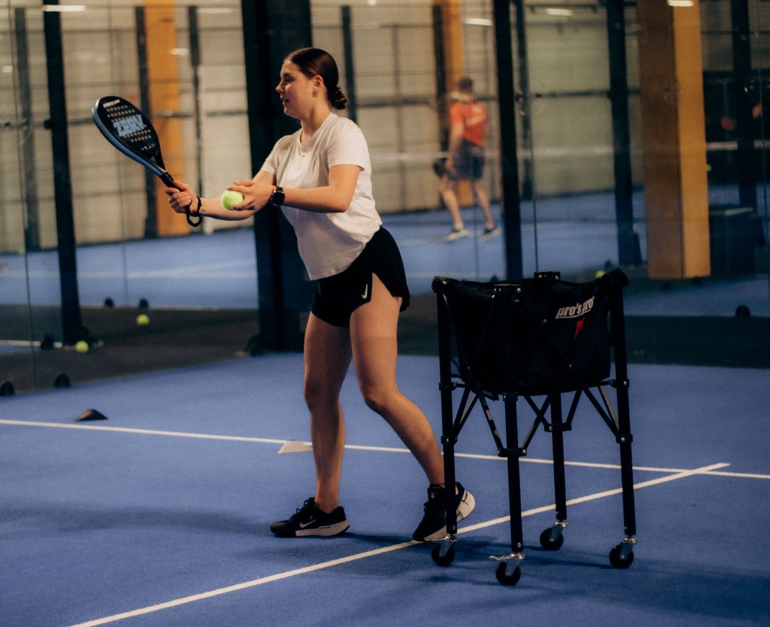 Einsteigerin beim Padel-Training auf dem Court