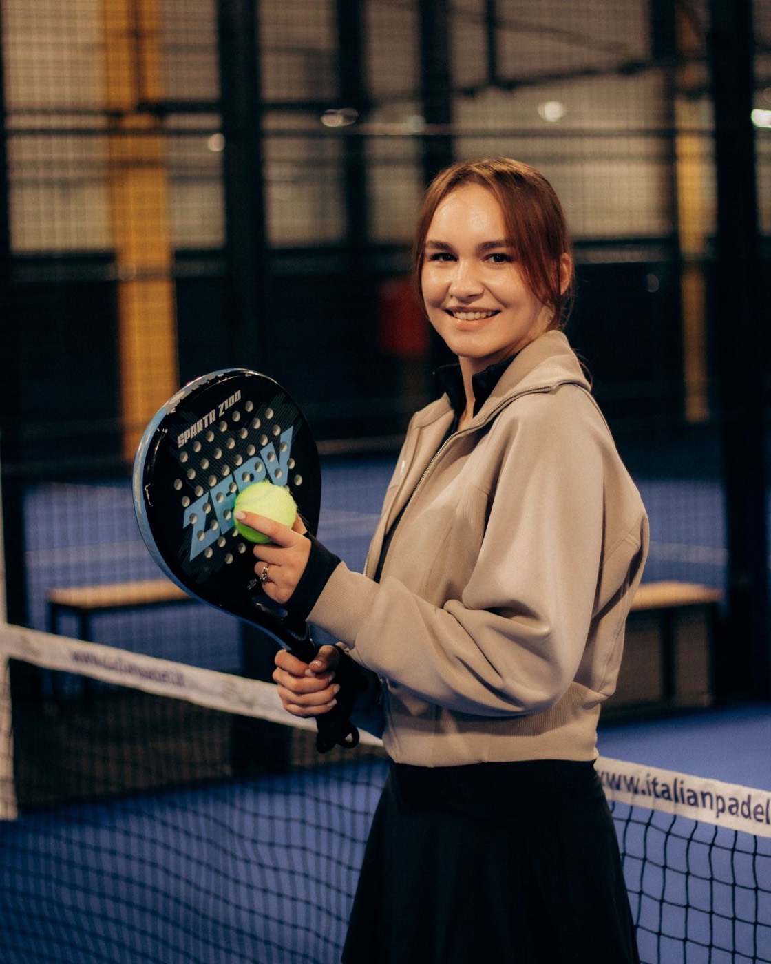 Lächelnde Einsteigerin mit Padel-Schläger